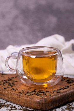 Green tea. Green tea in a wooden serving dish on a stone background. Healthy drinks. Herbal tea concept. close up