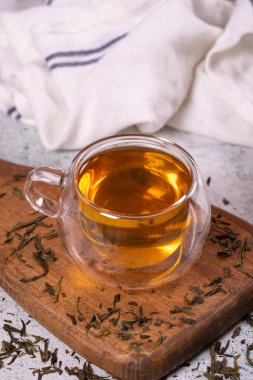 Green tea. Green tea in a wooden serving dish on a stone background. Healthy drinks. Herbal tea concept. close up