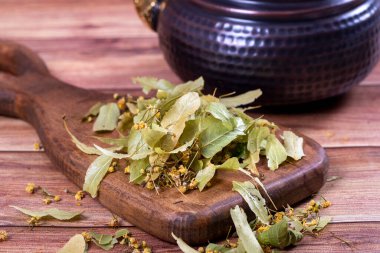 Leaves of linden tea. Dried linden tea on wood floor. Herbal tea concept. Healthy drinks. close up