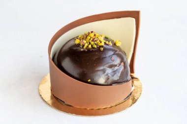 Chocolate and pistachio cake. Cake surrounded by chocolate on a white background. close up