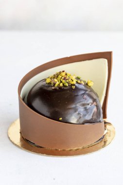 Chocolate and pistachio cake. Cake surrounded by chocolate on a white background. close up