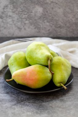 Ripe pear on a dark background. Fresh and juicy pear on the plate. Organic food. close up