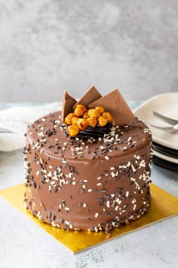 Birthday cake with croquant on gray background. Chocolate covered cake with croquant and cream inside. close up