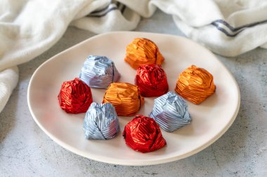 Special chocolate or gilded chocolate. Chocolates covered on gray background. Local name yaldizli cikolata. close up