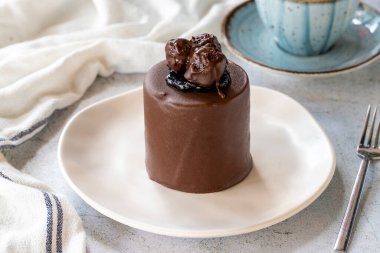 Chocolate cake on gray background. Fruit and cream cake covered with chocolate on the outside. close up