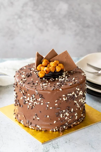 Birthday cake with croquant on gray background. Chocolate covered cake with croquant and cream inside. close up