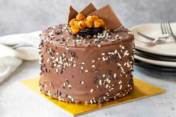 Birthday cake with croquant on gray background. Chocolate covered cake with croquant and cream inside. close up