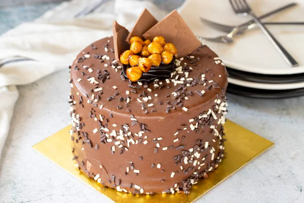 Birthday cake with croquant on gray background. Chocolate covered cake with croquant and cream inside. close up