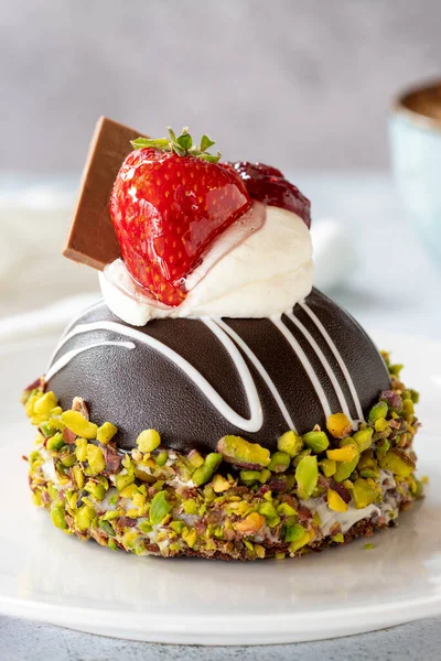 Pistachio and strawberry cake on gray background. Fruit and cream cake covered with chocolate on the outside. close up