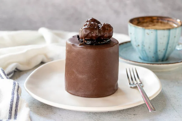 Chocolate cake on gray background. Fruit and cream cake covered with chocolate on the outside. close up