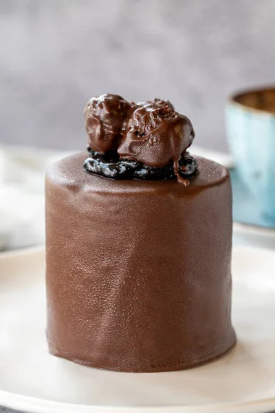 Chocolate cake on gray background. Fruit and cream cake covered with chocolate on the outside. close up