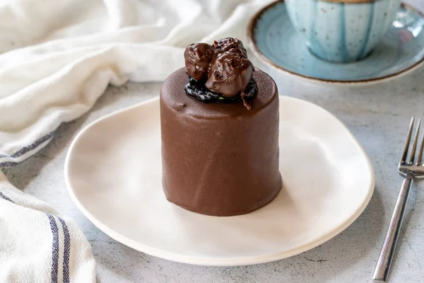 Chocolate cake on gray background. Fruit and cream cake covered with chocolate on the outside. close up