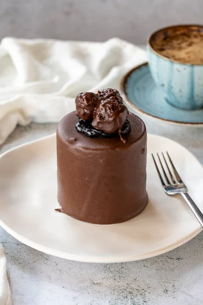 Chocolate cake on gray background. Fruit and cream cake covered with chocolate on the outside. close up