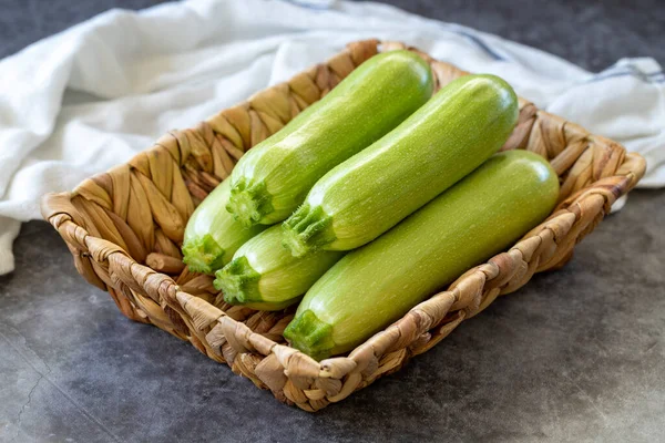 Organic zucchini. Fresh zucchini in basket on dark background. Vegetable, healthy vegan food. close up