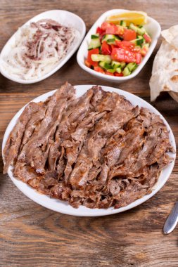 Meat doner kebab on the plate. Turkish meat doner kebab on wooden background. Traditional Turkish cuisine. close up