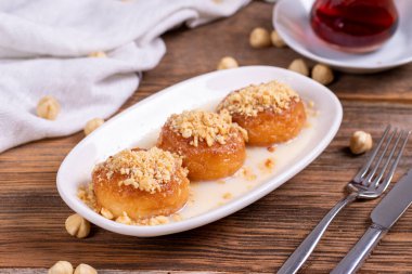 Milky kemalpasa dessert. Dessert with milk and hazelnuts on wooden background. Traditional Turkish cuisine. Close-up. local name sutlu kemalpasa tatlisi