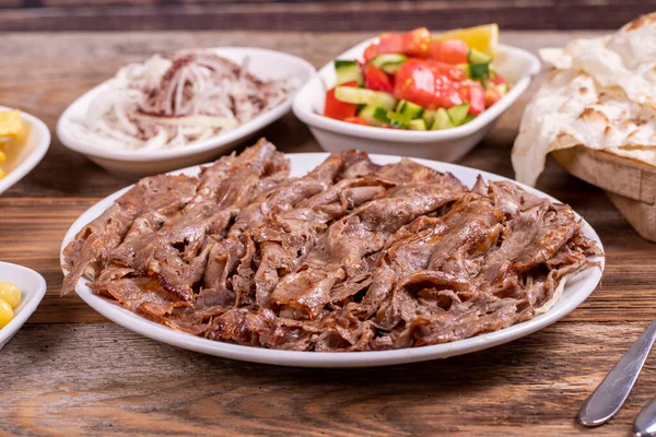 Meat doner kebab on the plate. Turkish meat doner kebab on wooden background. Traditional Turkish cuisine. close up