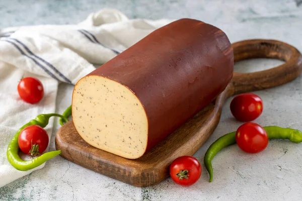 Black Pepper Smoked Cheese. Dutch smoked cheese on stone background. close up