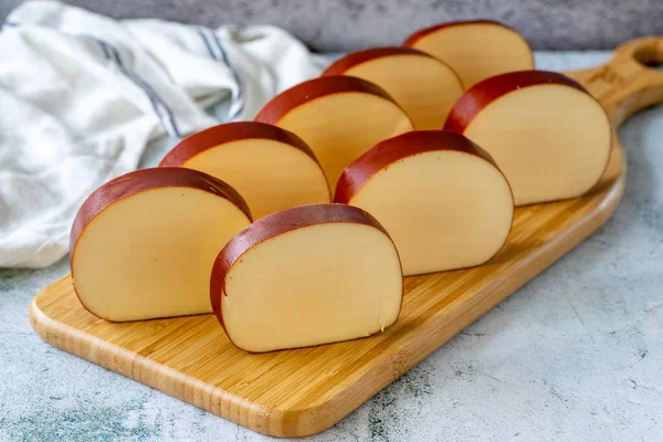 Smoked cheese. Dutch smoked cheese on stone background. close up