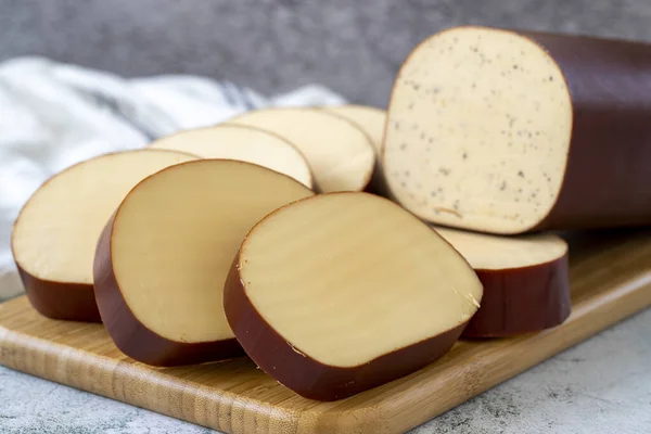 Smoked cheese. Dutch smoked cheese on stone background. close up