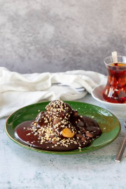 Profiterole. Chocolate profiteroles dessert on plate on gray background. close up