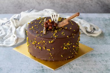 Celebration cake with pistachio and chocolate. Birthday cake on gray background. close up