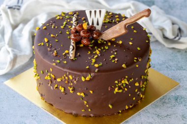 Celebration cake with pistachio and chocolate. Birthday cake on gray background. close up