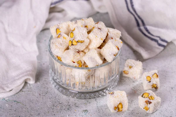 Turkish Delight with Coconut and Pistachio. Sweet Turkish delight on gray background. Traditional Turkish delicacies. close up