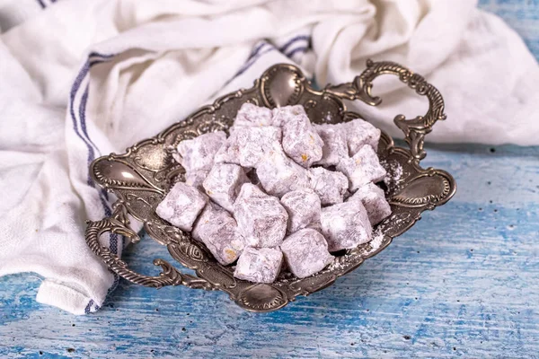 Turkish Delight with Pistachio. Sweet Turkish delight on blue background. Traditional Turkish delicacies. close up