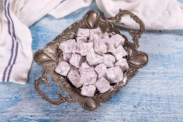 Turkish Delight with Pistachio. Sweet Turkish delight on blue background. Traditional Turkish delicacies. close up