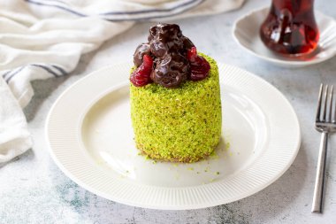 Fıstıklı ve meyveli kek. Gri arka planda kek. Kapat.