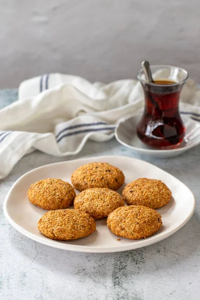 Susamlı kurabiye. Gri arka planda taze pişmiş tuzlu kurabiyeler. Kapat.