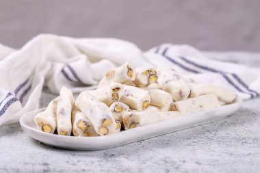 Süt aromalı Türk lokumu. Fıstıklı Türk Lokumu ve gri arka planda süt fitili. Geleneksel Orta Doğu mutfağı lezzetleri. Kapat.