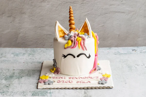 Special design cake in the shape of a unicorn. Design birthday cake on gray background