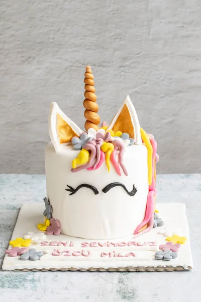 Special design cake in the shape of a unicorn. Design birthday cake on gray background