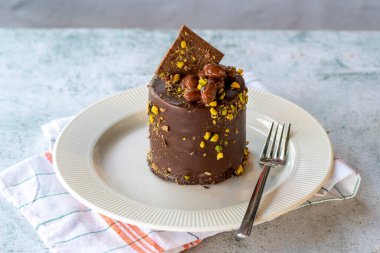 Çikolatalı pasta. Gri arka planda fıstıklı ve çikolatalı pasta. Kapat.