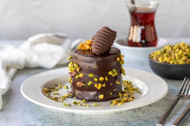 Fıstıklı kek. Fırın ürünleri. Gri arka planda çikolata ve şam fıstıklı kek. Kapat.