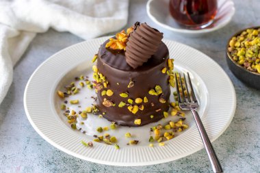 Fıstıklı kek. Fırın ürünleri. Gri arka planda çikolata ve şam fıstıklı kek. Kapat.