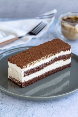 Tiramisu keki. Fırın ürünleri. Gri arka planda kakao ve kahveli kek. Kapat.