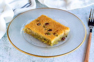 Fıstıklı Kadaif tatlısı. Geleneksel Akdeniz mutfağı lezzetleri. Gri arka planda Kadayif. Kapat.
