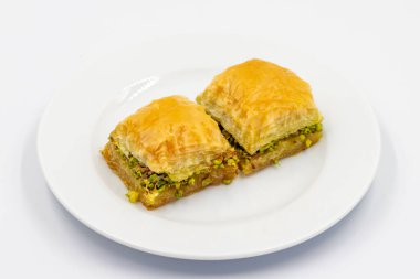 Beyaz arka planda şam fıstıklı baklava. Geleneksel Türk mutfağı lezzetleri. Kapat.