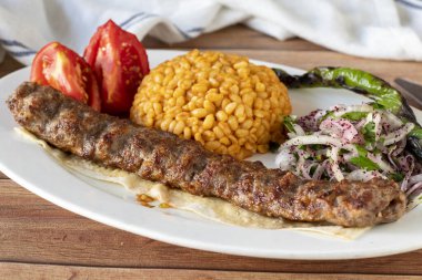 Ahşap arka planda Adana kebabı. Geleneksel Türk kebabı lezzetleri. Kapat.