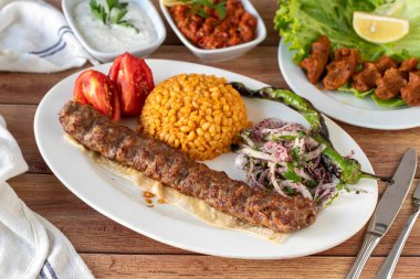 Ahşap arka planda Adana kebabı. Geleneksel Türk kebabı lezzetleri. Kapat.
