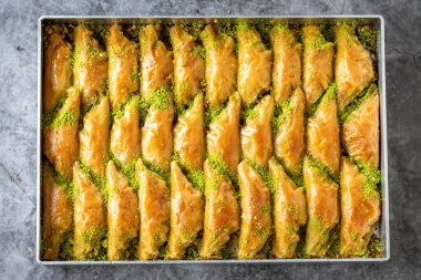 Fıstıklı sobiyet baklava. Karanlık arka planda tepsi baklavası. Geleneksel Türk mutfağı lezzetleri. Kapat.