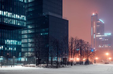 Katowice, Polonya - 09 Aralık 2021: Kentsel kış manzarası. aydınlatmalı modern ofis binası 