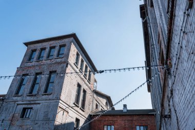 Porselen Fabrikası 'nın (Fabryka Porcelany) Katowice, Silesia, Polonya' daki eski sanayi binaları. Binalar arasında hafif çelenkler açılmış. Güzel, güneşli bir gün. 