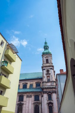 Polonya 'nın Nysa kentindeki Kutsal Bakire Meryem Varsayımı Kilisesi (Kosciol Wniebowziecia Najsweitszej Marii Panny). İlkbaharda ön planda modern bina ve ağaç.