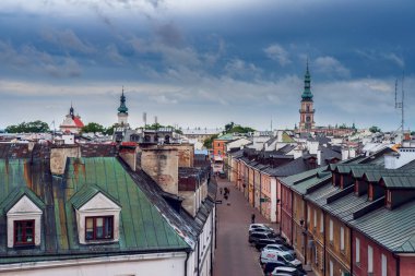 Zamo, Polonya - 10 Temmuz 2022: Surlardan eski kasabanın görüntüsü. Apartman dairelerinin çatıları. Arka plandaki kilise kulesi. Zamosc, Polonya.