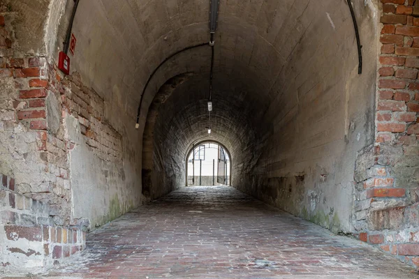 Tunnel through the fortification in the old town of Zamosc. Barrel vault. Brick walkway. Zamosc, Poland