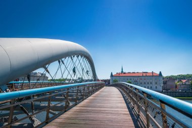 Cracow, Poland - August 27, 2022: Father Bernatek Footbridge. Artistic sculptures attached to the bridge structure. City in the background